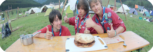 Drei Pfadfinder heben den ok-Daumen, vor ihnen ein Riesenburger